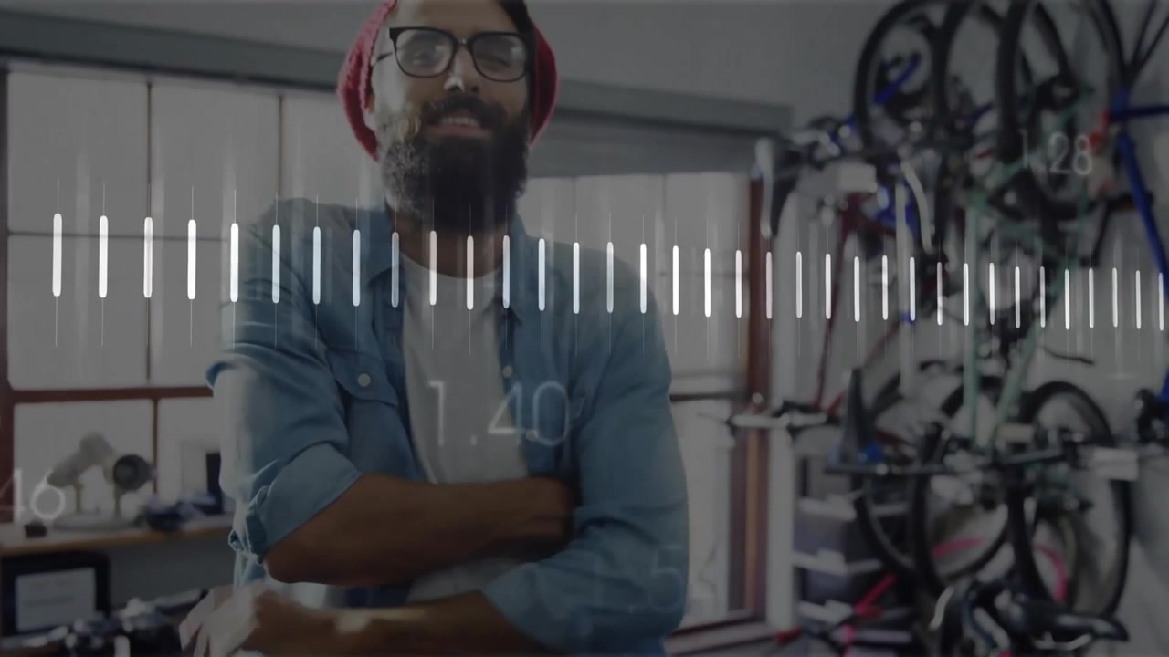 Mechanic leaning over bicycle adjusting brake in workshop with waveform scrolling for analysis