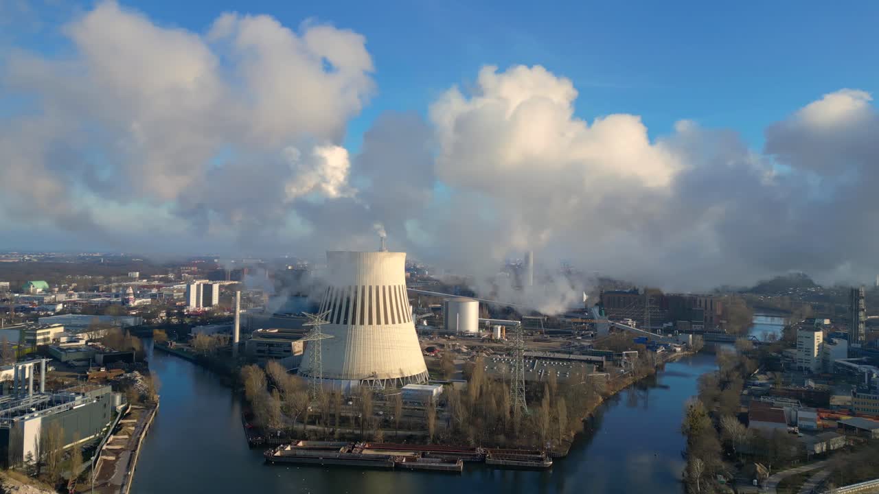Waste to energy plant emitting smoke from its chimney, located near an urban area, environmental impact of waste. Beautiful aerial view flight rotation to right drone