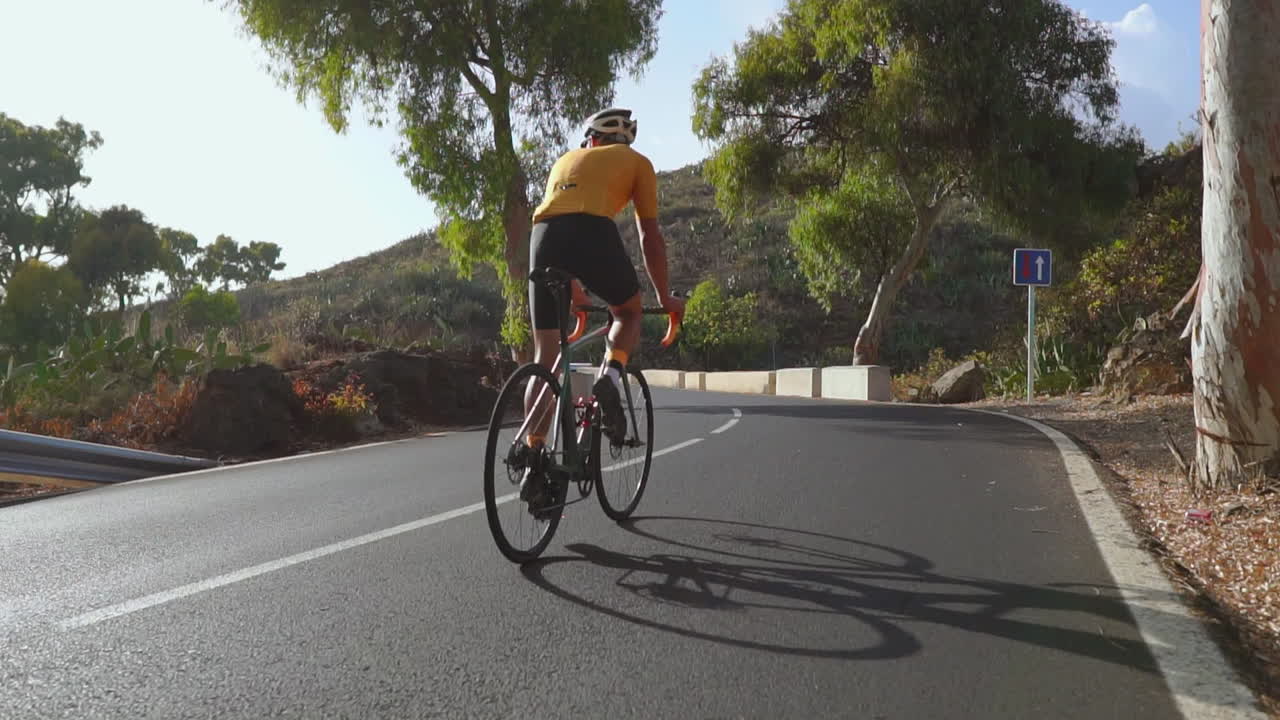 Godendosi una mattinata tranquilla, un uomo pedala sulla sua bici da corsa per fare esercizio all'aperto lungo una strada serena. Il filmato al rallentatore cattura l'essenza degli sport estremi.