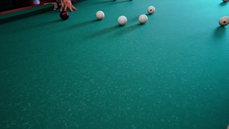 caucasian male playing russian biliard, the game is known as pyramid billiards