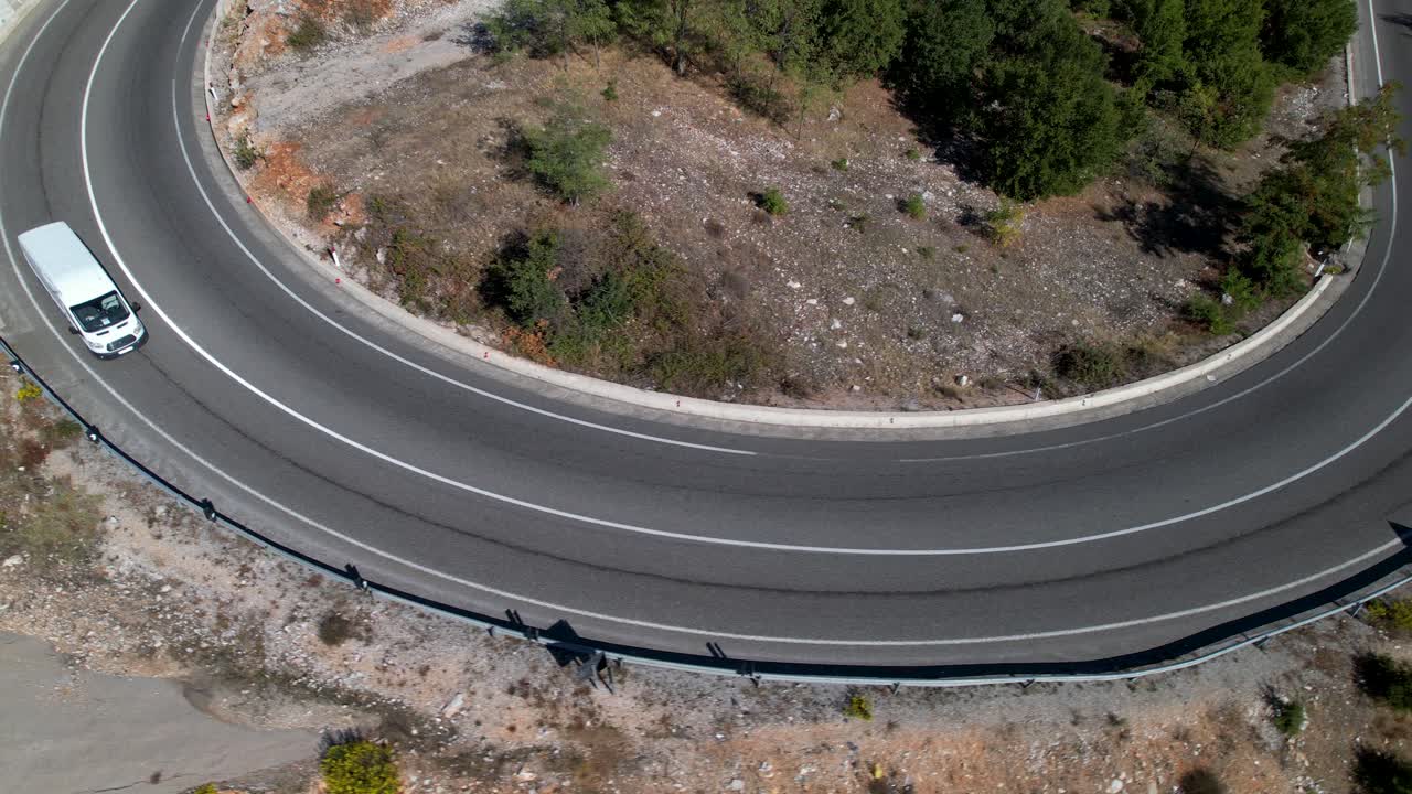 Curva de estrada em área montanhosa com carros dirigindo no asfalto, conceito de transporte para viagens.