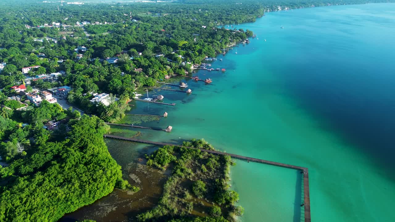 Drone aerial landscape of boardwalk waterfront of Bacalar lagoon lake town suburbs of Quintana Roo Mexico rainforest resorts vacation tropical holidays tourism travel nature