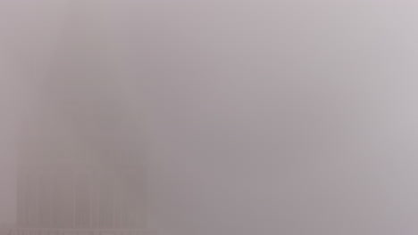 the clock hand spinning on a church or building tower on a foggy day in san francisco - time lapse