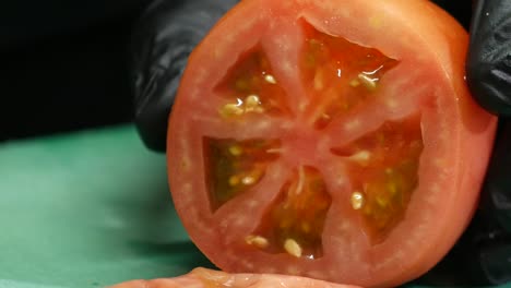 Primer-Plano-De-Manos-Enguantadas-Cortando-Un-Tomate-En-Rodajas