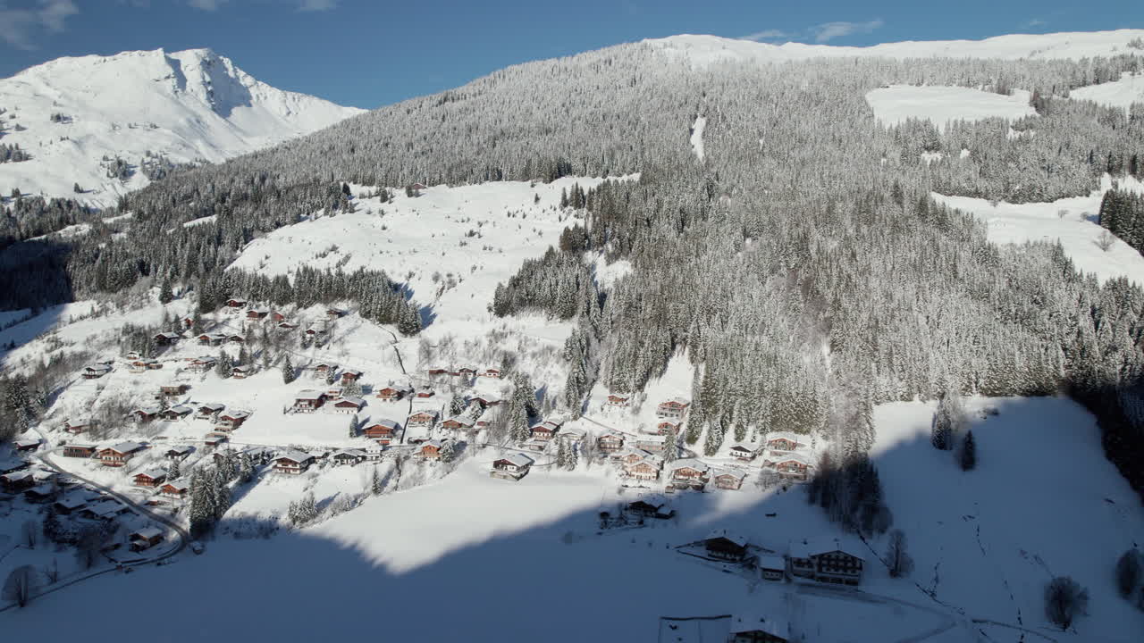 asentamientos cubiertos de nieve y bosques en las montañas de saalbach-hinterglemm, austria