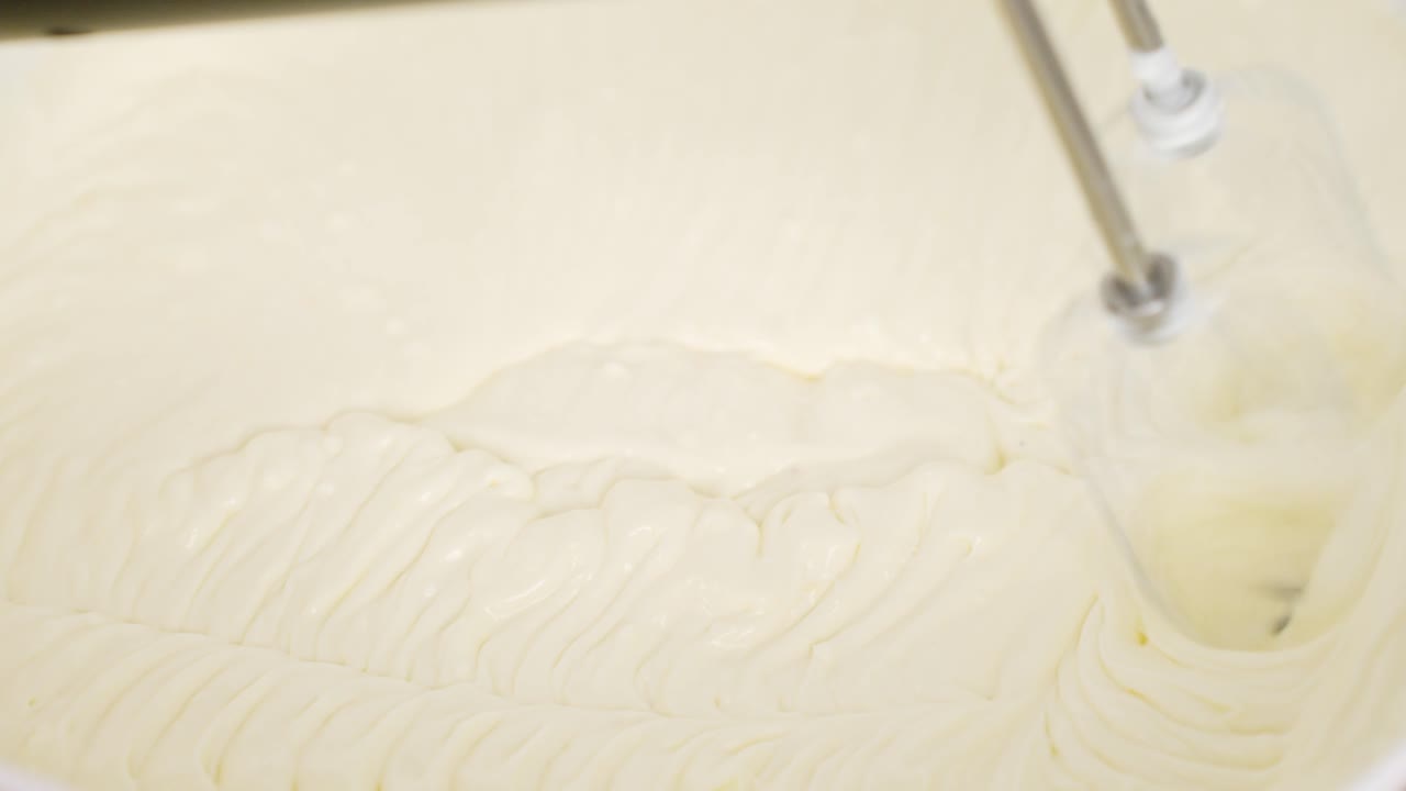 Close-up of mixing tiramisu dough, blending ingredients smoothly for a creamy dessert base.