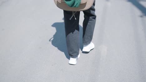 young man walking with guitar on street near forest