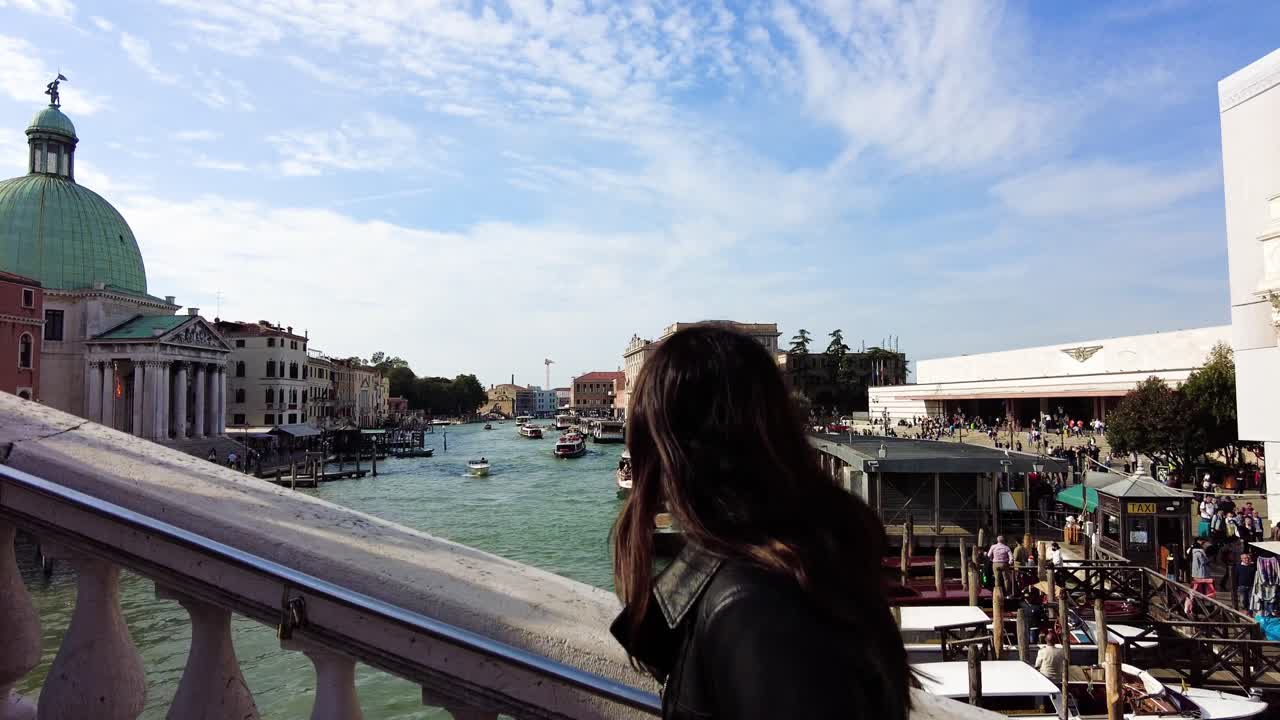 이탈리아 베니스의 대운하를 바라보며 리알토 다리로 올라가는 남아시아 여성