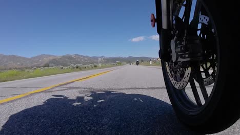 riding motorbike on open road, slow motion front wheel perspective