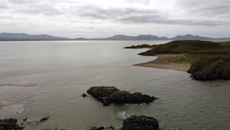 aerial view ynys llanddwyn island anglesey coastal walking trail with snowdonia mountains descent above irish sea