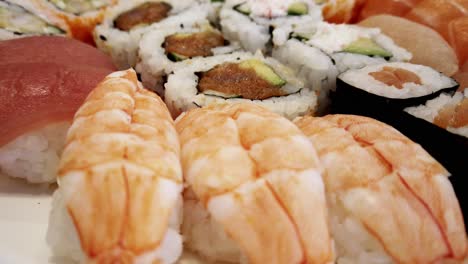 Verschiedene-Sushisorten-Auf-Einem-Teller-Angeordnet-Und-Unter-Einer-Nahaufnahme-Der-Kamera-Rotierend,-Wobei-Die-Bunten,-Detaillierten-Sushistücke-Schön-Und-Appetitlich-Aussehen,-Um-Sie-Sofort-Zu-Erreichen-Und-Zu-Essen