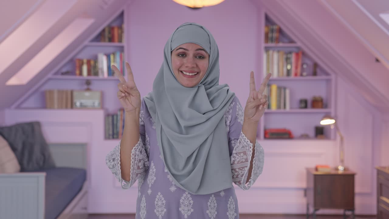 행복 한 무슬림 여자 는 승리 의 표시 를 보여 준다