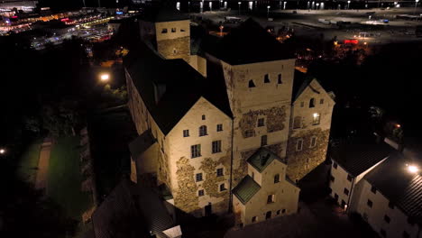 aerial descending shot in front of the turku castle, nighttime in abo, finland