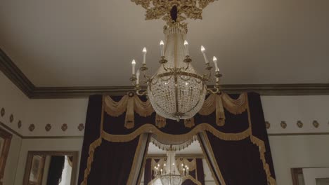 antique gold chandeliers with lit up candles at a mansion wedding venue