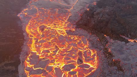 top down high angle drone aerial of molten lava fields and snow falling at the fagradalsfjall volcano eruption in iceland