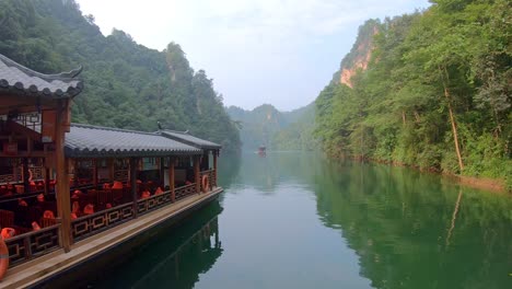 barcos turísticos navegando entre el impresionantemente hermoso paisaje cárstico que rodea el lago baofeng, wulingyuan, parque forestal nacional de zhangjiajie, provincia de hunan, china, asia