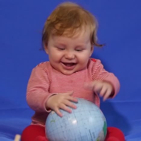 little boy playing with an globe