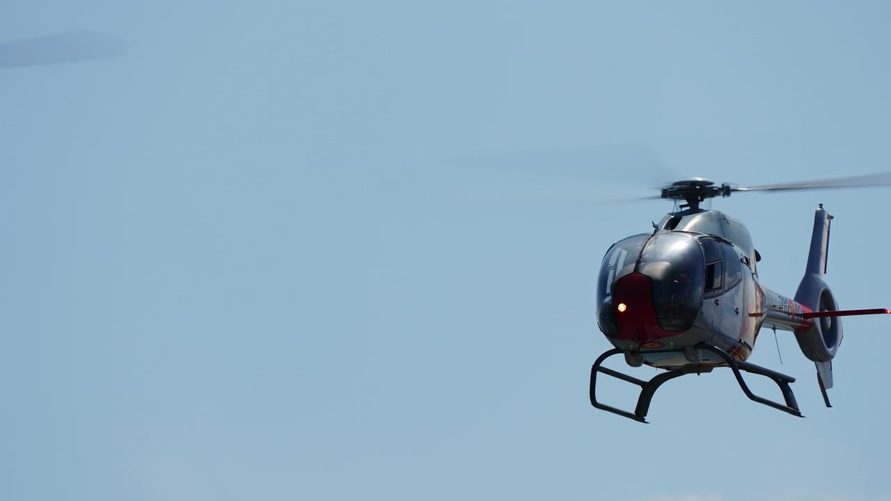 Quatre hélicoptères militaires volant en formation diagonale serrée.