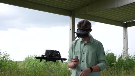 dron fpv frente a un joven piloto con gafas vr auriculares y control remoto de movimiento