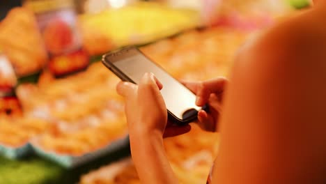 person using smartphone at vibrant phuket street food market