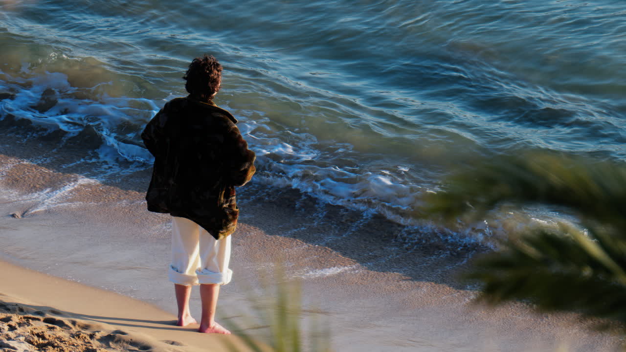 A man with bare feet walking on the beach, near the sea in Cannes, France