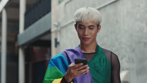 smiling person using smartphone with pride flag