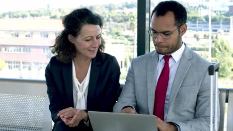 smiling business colleagues using laptop