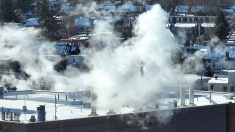 Dense-fumes-of-smokestacks-on-top-of-roof-in-american-town