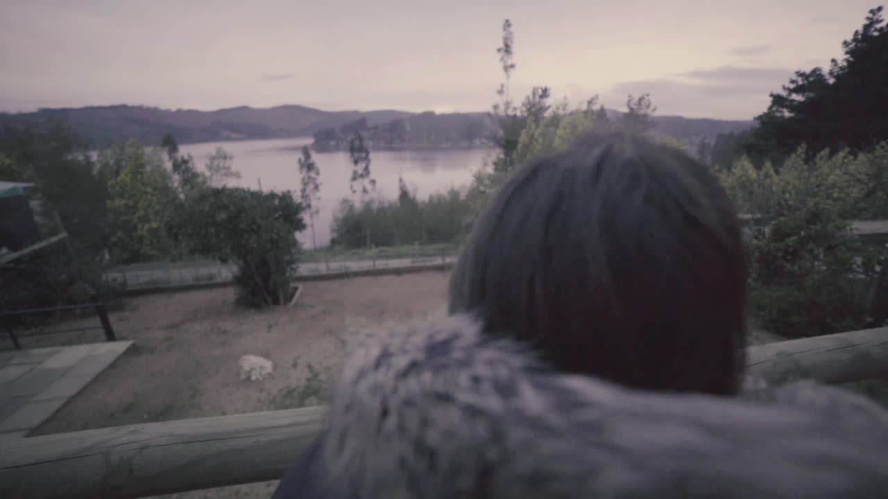 HD of a woman and her dog outdoog house in front of a lake