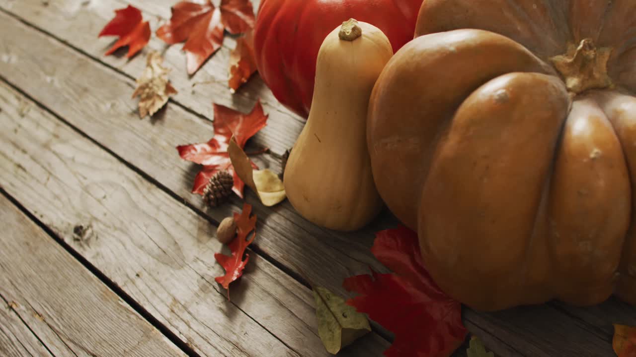 video de calabazas con piñas y hojas de otoño sobre fondo de madera
