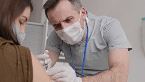 careful doctor giving vaccine injection