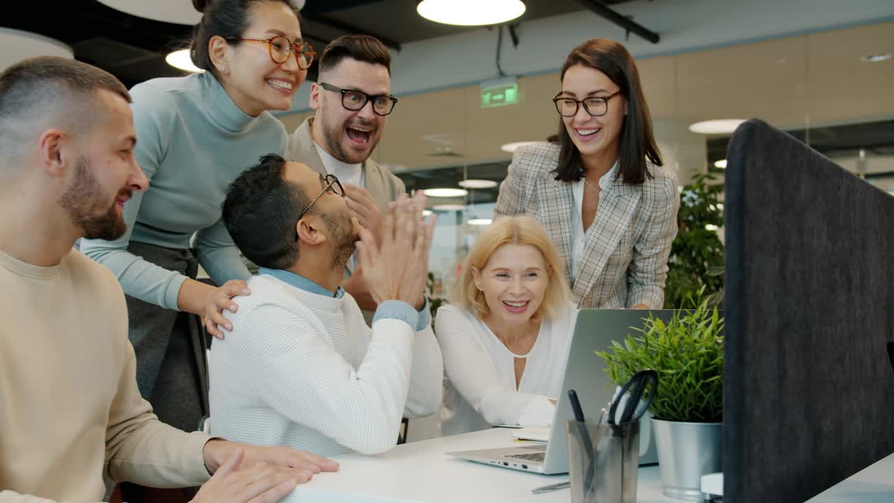 equipa multiétnica a falar, a bater palmas, a dar uns cinco no escritório ao ar livre.