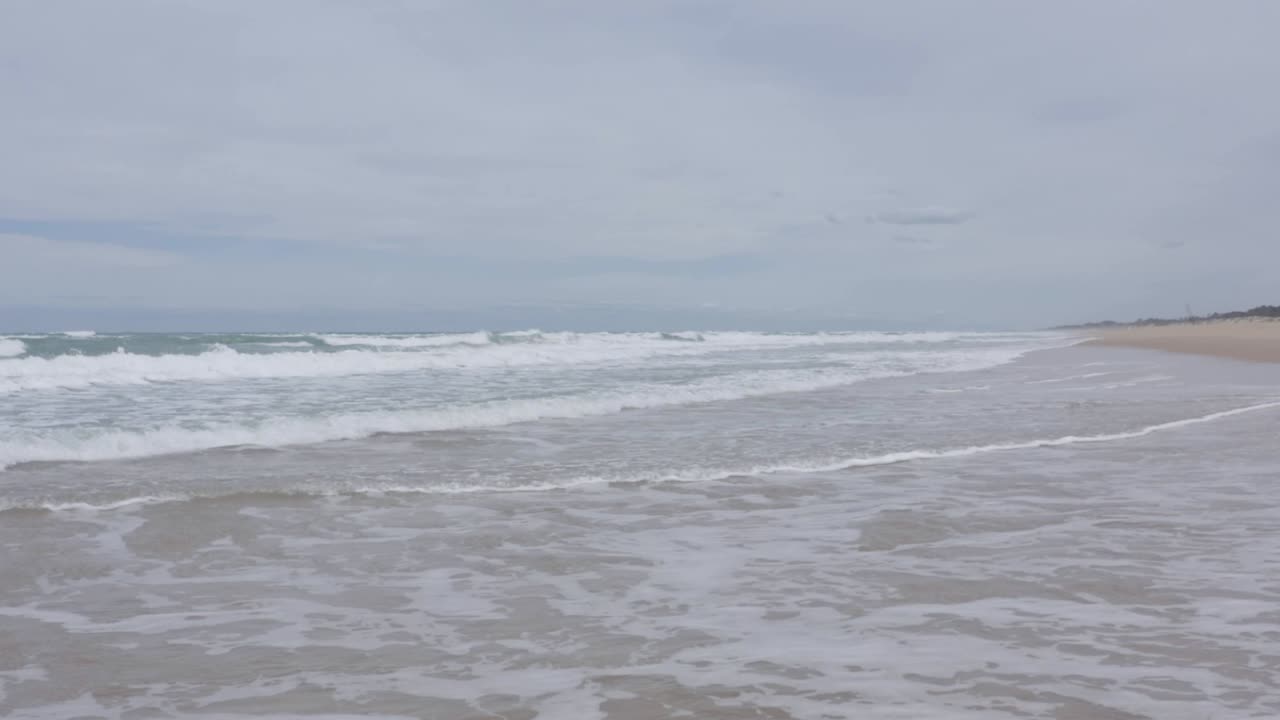 호주 해안선의 파도 위로 드론 비행을 닫고, 파도가 해변에 충돌하고, 사람이 없고, 일광