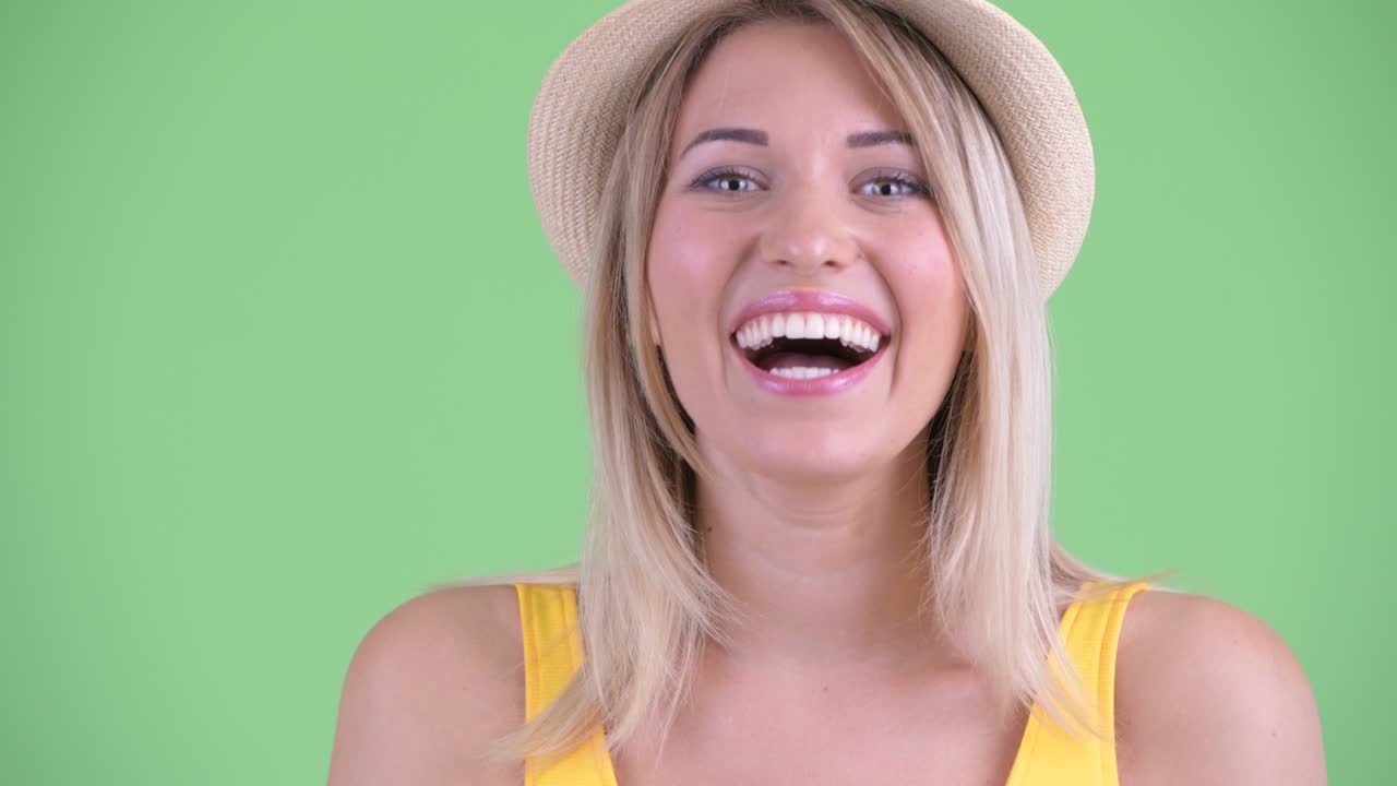 zoom en el tiro de la joven turista mujer mirando conmocionado contra el fondo verde