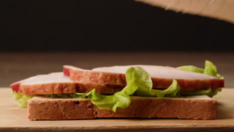 making a ham and lettuce sandwich