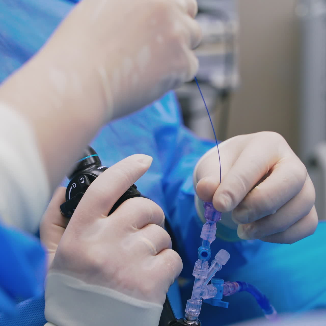 Modern medical equipment in surgeon's hands. Specialist with the help of a nurse perform a complex surgery. Close-up.