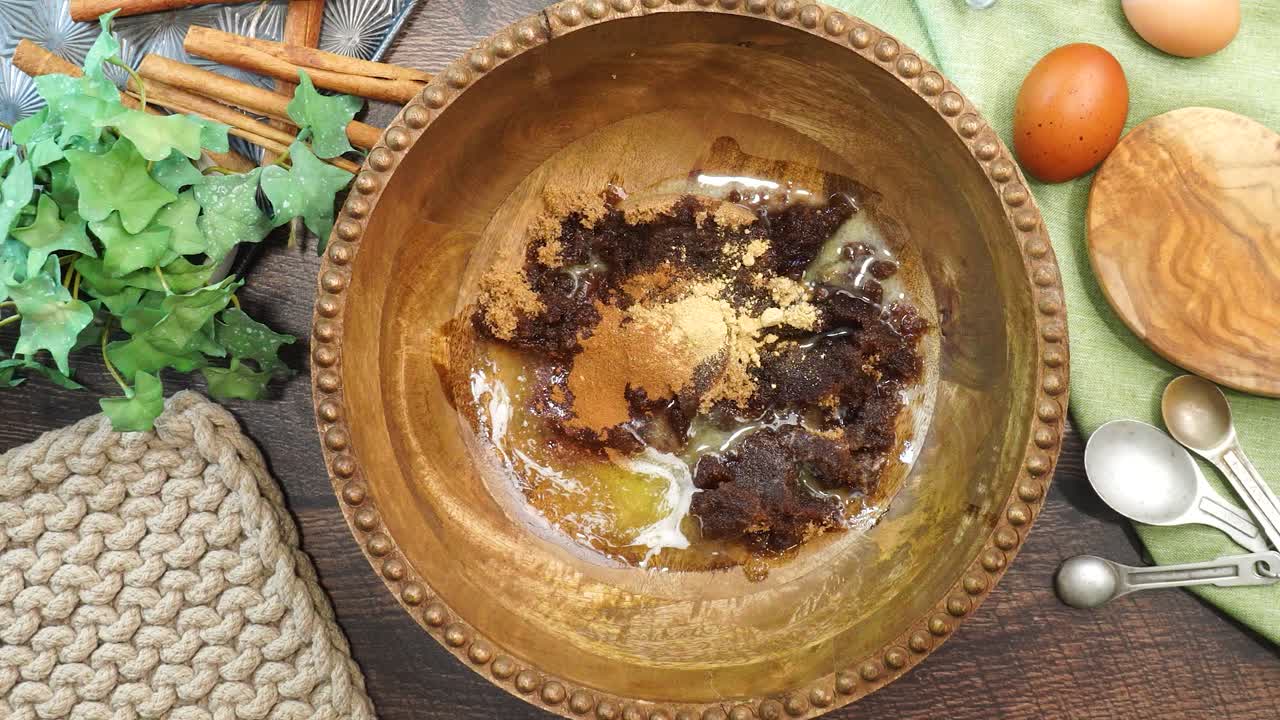 Baking a carrot cake loaf with cream cheese icing and topped with roasted salted pecans. Making a Autumn dessert with carrots, flour, sugar, nuts and frosting. Adding in salt to the carrot cake batter