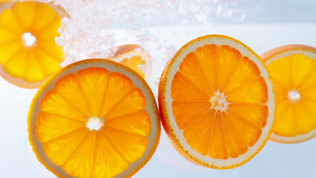 Fette d'arancia vivaci immerse nell'acqua, bolle scintillanti e movimento delicato creano un'estate vibrante e rinfrescante