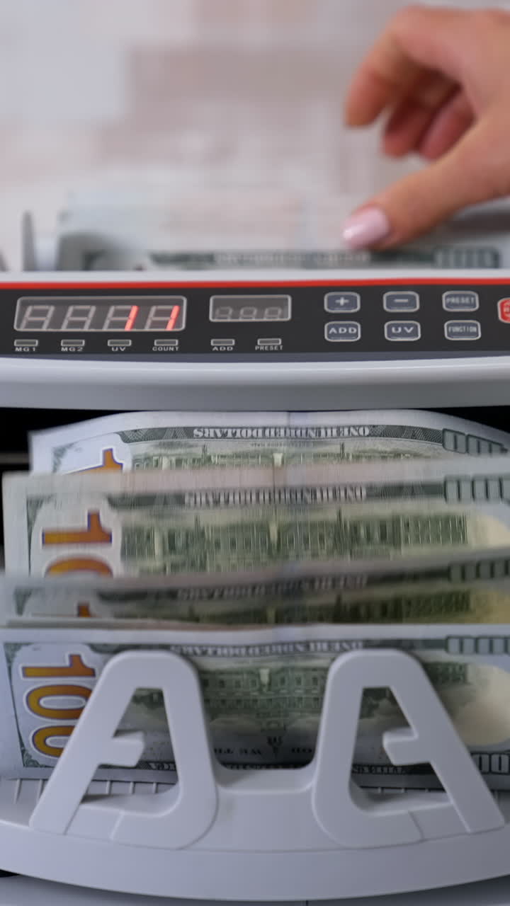 Money counting machine. Counting dollar banknotes. Vertical video