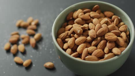 Video-of-fresh-fruit-almonds-in-a-bowl-on-grey-background