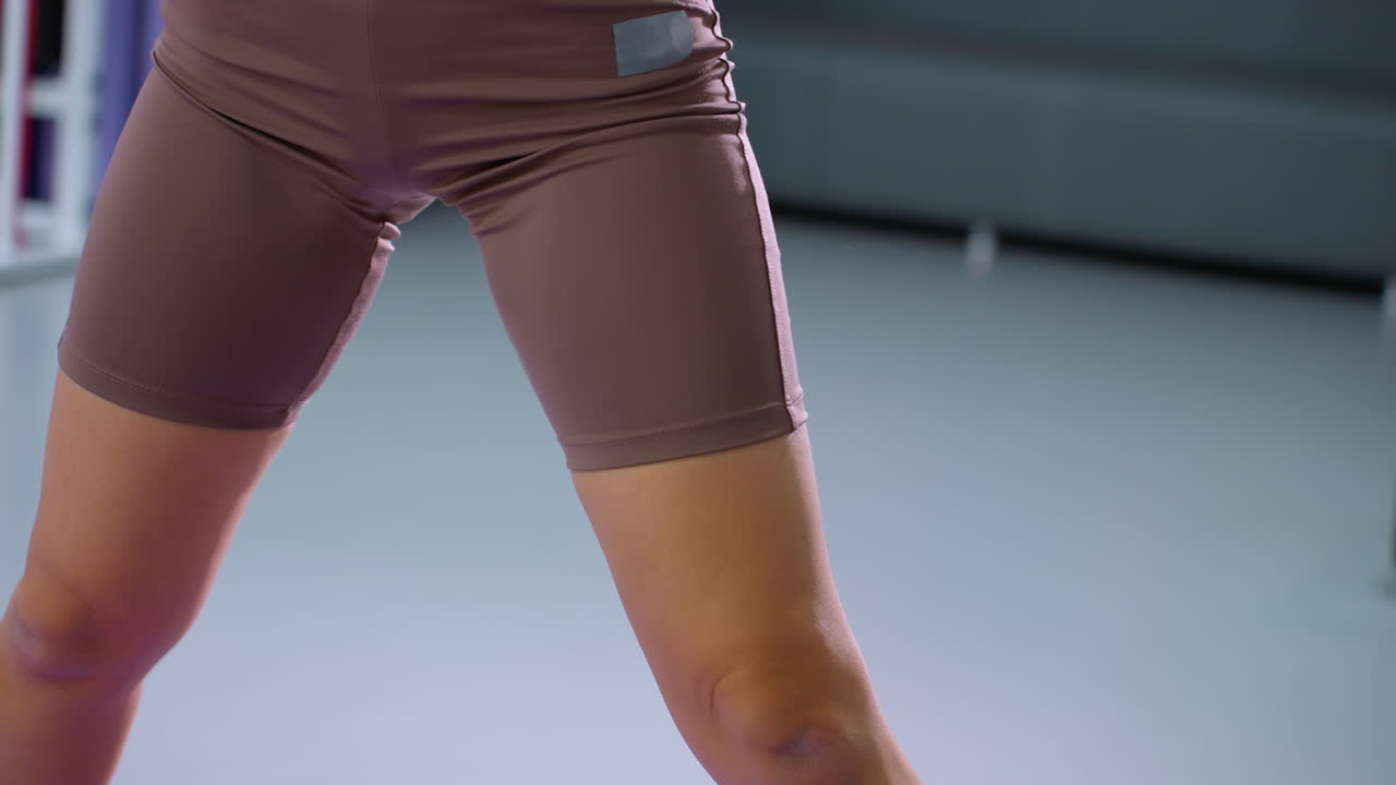 Woman engages in abs-building fitness exercise using a foam roller, wearing a smart watch for tracking performance, focus on toned body, strength, and endurance training in a modern gym environment