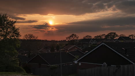 The-setting-sun-over-a-housing-estate-in-Worcestershire,-England-as-the-evening-clouds-blow-by