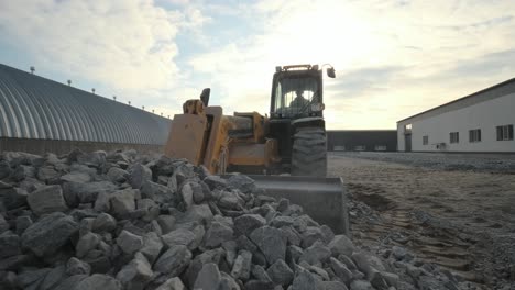 tractor mueve escombros al camión. excavadora-cargador rastrilla escombros de la pila en el sitio de construcción y carga el camión de descarga. sitio de limpieza