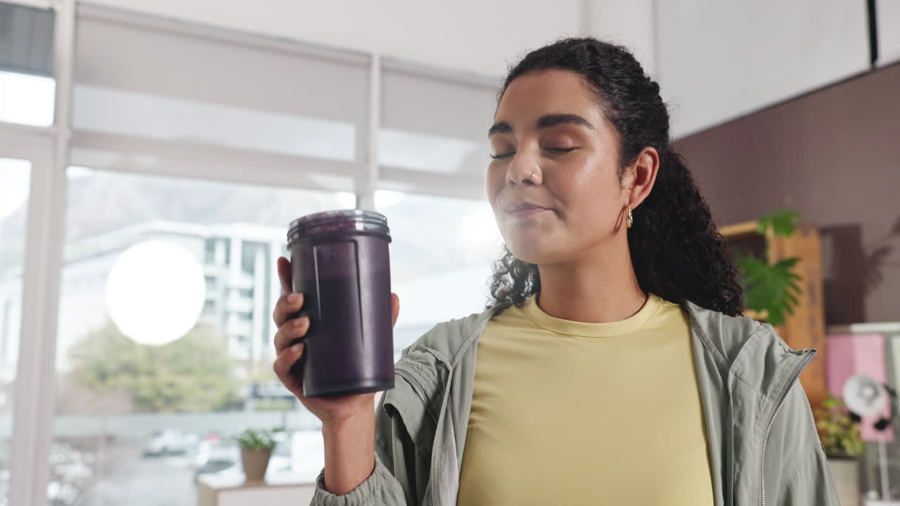 Woman holding a purple smoothie