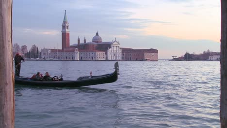 a gondola is rowed in front of isola di san giorgio maggiore in venice italy 1