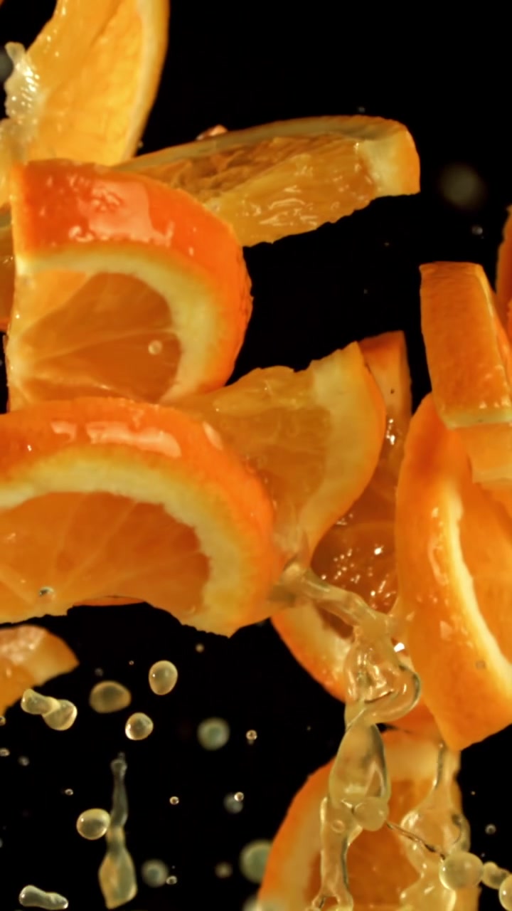 Fette d'arancia fresche e succo che schizzano al rallentatore