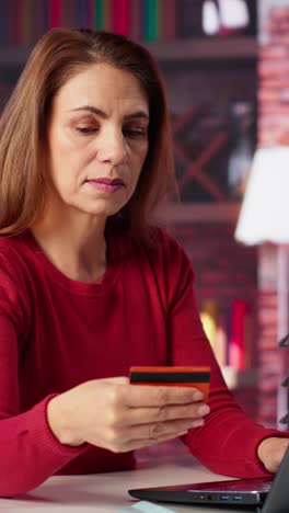 vertical video casual woman staying at home and paying for things online on laptop