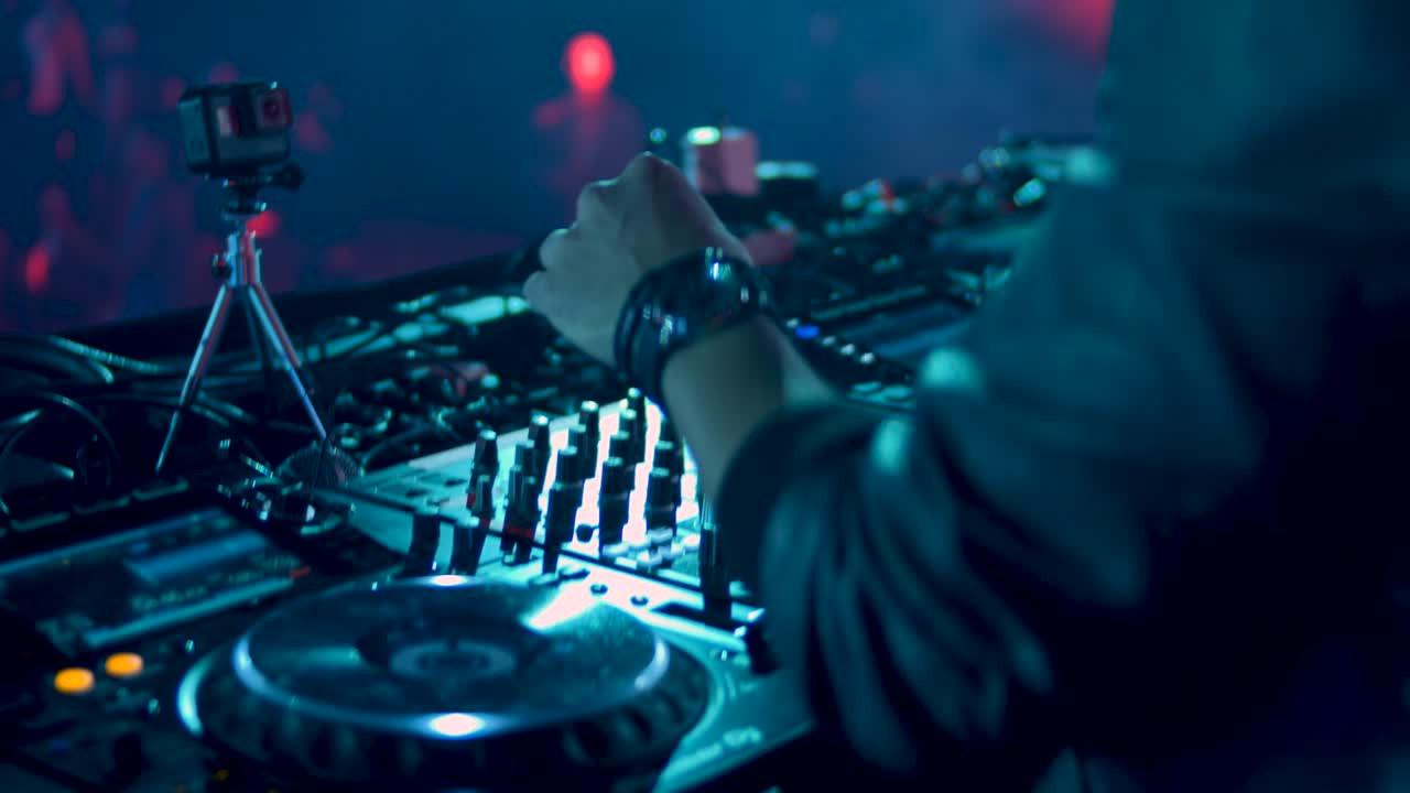 DJ mixing music on a turntable at a nightclub