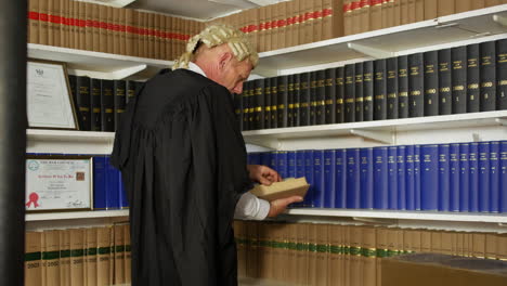 a judge or barrister lawyer in a law library on a ladder reaching for a book