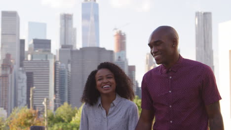 couple visiting new york with manhattan skyline in background